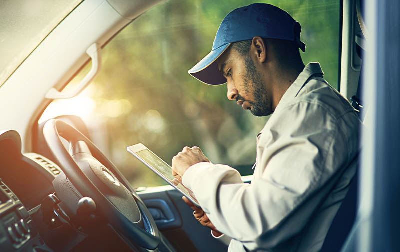 Man checking tablet in truck