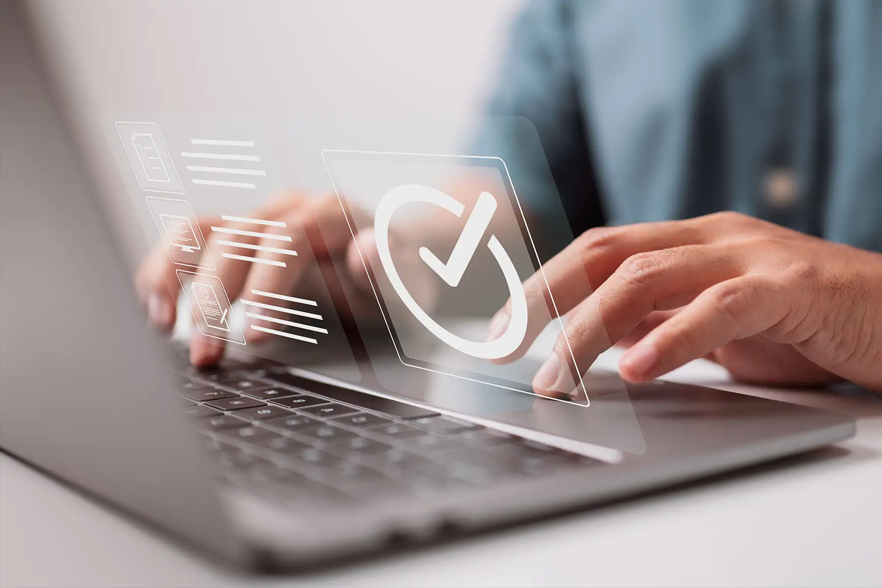 Hands on laptop keyboard with a checkmark icon floating in the air