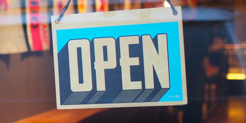 An "open" sign hangs in a storefront window