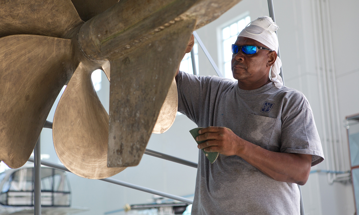 A DYS employee performs detailing services on a yacht.