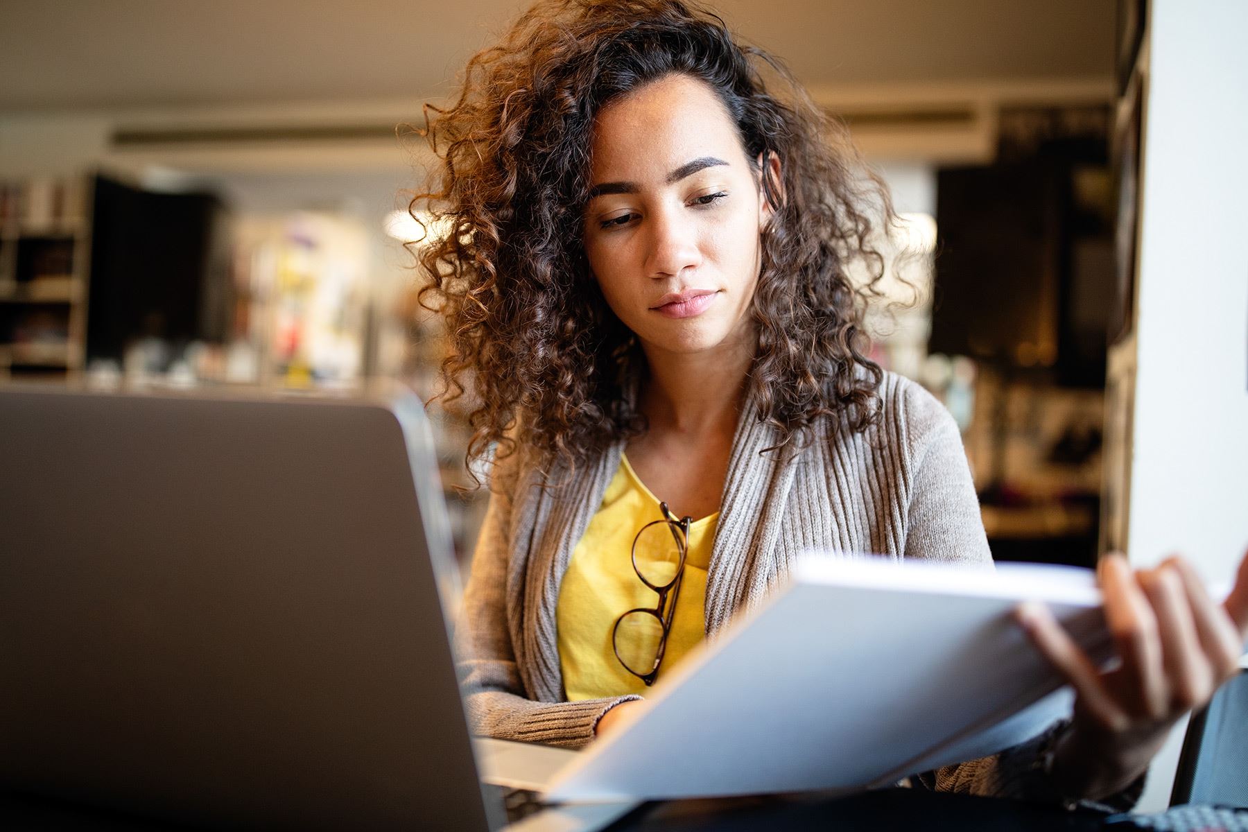 Woman looking at laptop and taking notes